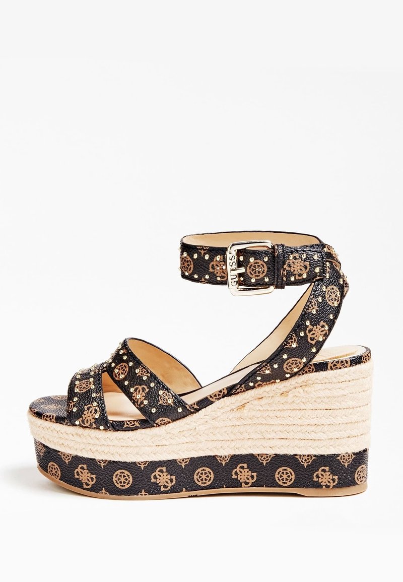Sandale compensée noire avec motif monogramme marron, bride de cheville avec boucle et semelle plateforme en corde tressée.