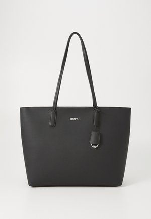 Svart tote-väska i konstläder, med två handtag, minimalistisk design och en silvrig logodetalj på framsidan.