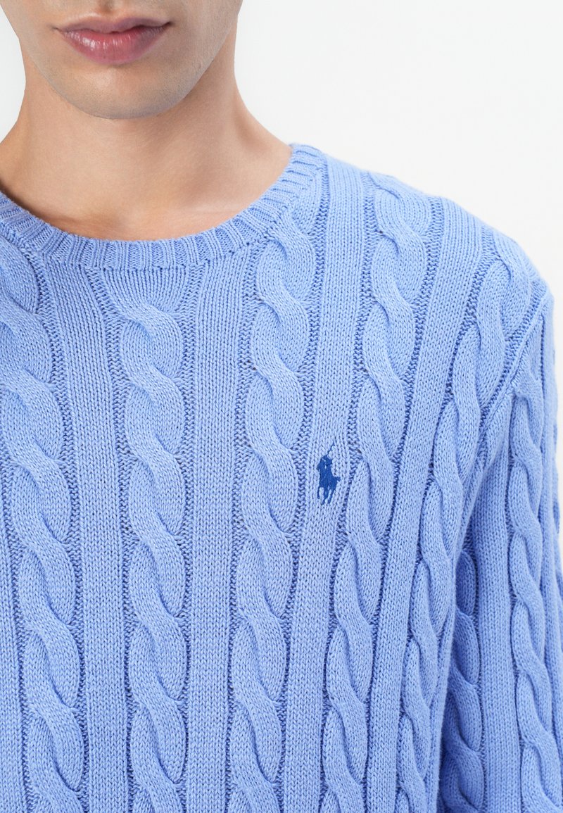 Maglione di cotone azzurro in lavorazione a trecce con scollatura rotonda e motivo testurizzato; presenta un piccolo logo blu scuro sul petto.