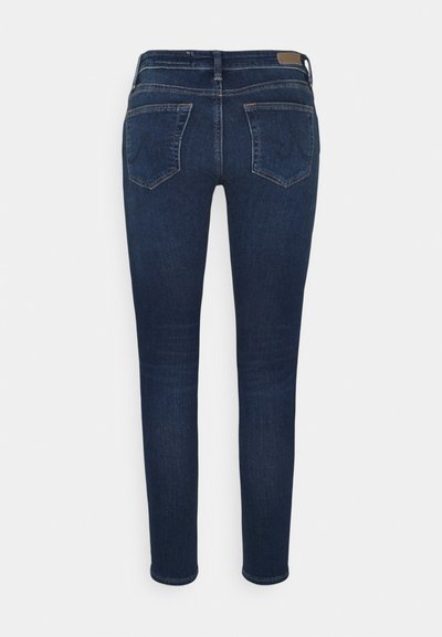 Jeans skinny azul escuro com uma textura de denim suave, apresentando dois bolsos traseiros e um corte reto desde a cintura até aos tornozelos.