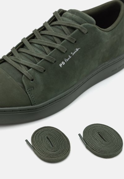 Green suede sneaker with flat laces, rounded toe, and stitched accents. Includes two matching green laces, minimalist branding on the side.