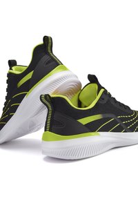 Black athletic shoes with neon green accents, featuring a textured upper, striped detailing, and a white rubber sole.