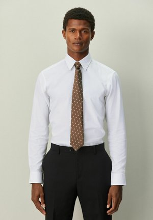White dress shirt with long sleeves, fitted collar, and a brown tie with a subtle pattern, paired with black trousers.