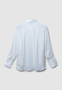Camicia bianca plissettata con colletto, maniche lunghe e polsini con bottoni. Tessuto leggero con una texture liscia e un sottile lucentezza.