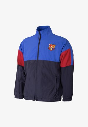 Windbreaker jack met blauwe bovenkant, rode mouwen en marineblauwe onderkant. Voorzien van een ritsluiting en geborduurd logo op de borst.