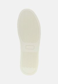 Suola di scarpa da ginnastica bianca in gomma con motivi a onda texturizzati e un logo rettangolare impresso al centro. Bordo liscio e punta arrotondata.