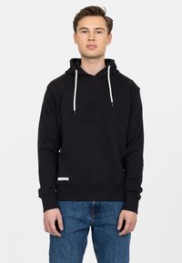 Felpa nera con logo testurizzato, cordini regolabili e polsini a costine. Un paio di jeans blu visibili sotto. Design semplice e casual.