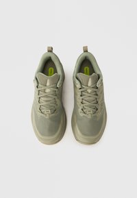 Baskets en mesh vert avec une surface texturée, un bout arrondi et des lacets structurés. Dotées de languettes au talon pour un enfilage facile.