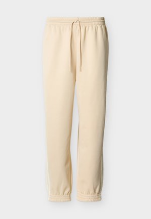 Beige sweatpants made of soft fabric, featuring an elastic waistband with a drawstring and ribbed cuffs; side stripes in a lighter shade.