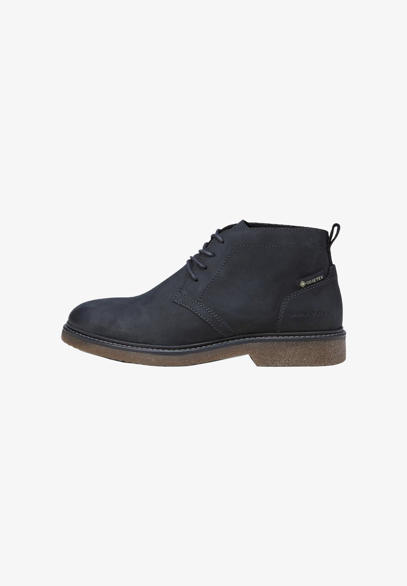 Bottines en cuir noir, à bout rond, à lacets sur le devant, avec une semelle en caoutchouc brun texturé. Présente un logo et un panneau imperméable sur le côté.