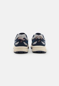 Blue and gray athletic shoes feature a textured mesh upper, padded collar, and a thick cream-colored sole with rubber tread.