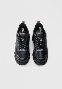 Fekete tornacipők irizáló díszítéssel, vaskos fekete talppal, fűzős kialakítással és színes márkajelzéssel a hátoldali pánton. Sima bőr és textil anyagból.