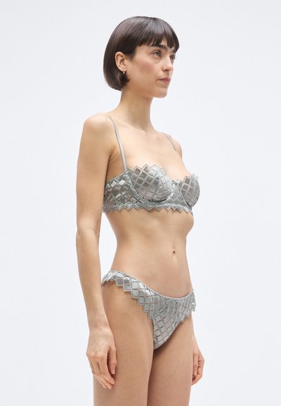 Srebrnosivi komplet donjeg rublja s uzorkom prošivanja, podesivim naramenicama, valovitim rubom na donjem dijelu i mekšim, teksturiranim završetkom.