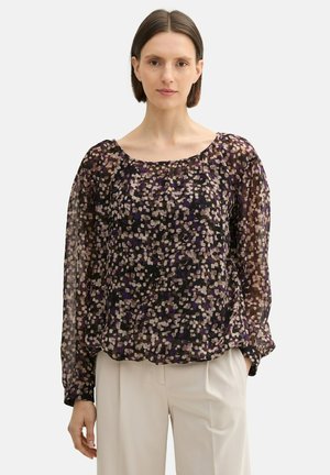 Blouse transparente à manches longues présentant un motif abstrait multicolore avec des nuances de violet, de noir et de crème ; coupe ample et décolleté rond.