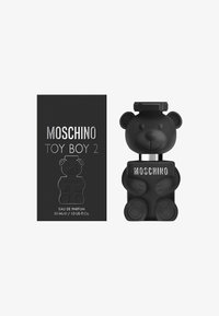 Butelka w kształcie czarnej niedźwiedzi z błyszczącym wykończeniem i kwadratową koreczka, obok czarnego pudełka z napisem "Moschino Toy Boy 2" w srebrnym kolorze.
