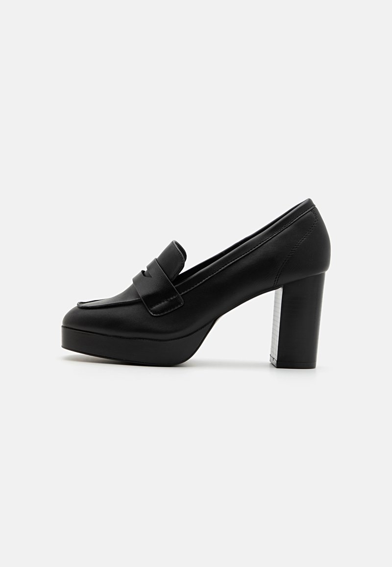Black leather high-heeled platform loafers with a rounded toe and a decorative strap. The heel features a textured silver accent.