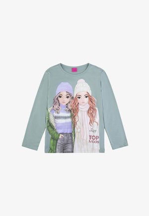 Camicia a maniche lunghe di colore verde chiaro con due ragazze illustrate in abbigliamento invernale, una con una giacca verde e l'altra con una sciarpa bianca.