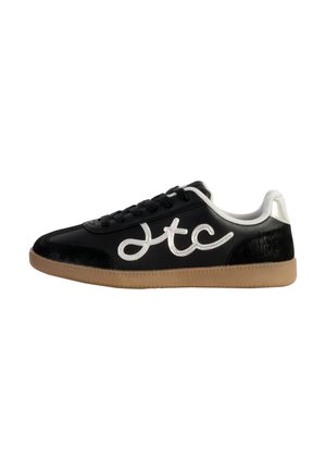 Baskets noires en cuir lisse, avec des accents argentés et un talon noir texturé. Présente un logo blanc bien visible sur le côté et une semelle en caoutchouc couleur gomme.