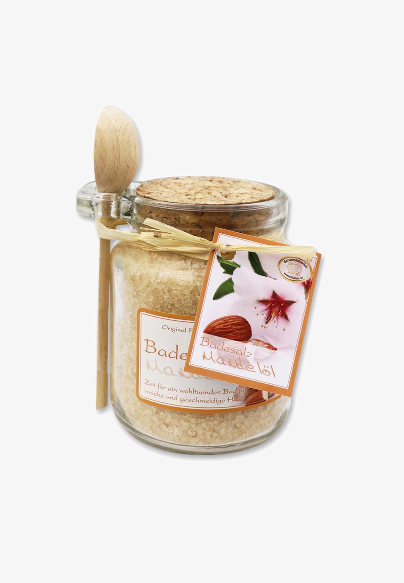 Glass jar filled with coarse, creamy bath salt, topped with a cork lid. Includes a wooden spoon and a label featuring an almond blossom.