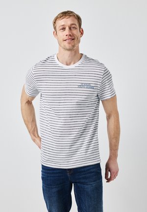 T-shirt rayé en blanc et marine, à manches courtes, col rond avec bord côtes, arborant une broderie "Le Soleil Toute L'Année" sur la poitrine.