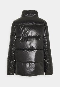 Skinande svart pufferjacka med hög krage och horisontella quiltade sektioner. Tillverkad av ett slätt, glänsande material med elastiska ärmslut.