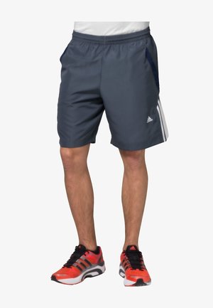 Shorts deportivos grises de material ligero, con bolsillos laterales, cintura con cordón y tres franjas blancas en uno de los lados.