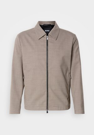 Braun karierter Reißverschlussjacke mit spitzem Kragen, seitlichen Taschen und glatter Textur. Mit einem metallischen Reißverschluss und dezenten Designdetails.