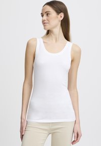 Valge ilma varrukateta t-tank top, mis on valmistatud siledast ja kergest kangast; omab ringikujulist kaelust ja on hästi istuv.
