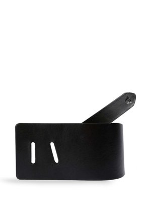 Cinturón de cuero negro con dos ranuras rectangulares y un extremo cónico sobre un fondo blanco.