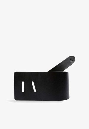 Cinturón de cuero negro con dos ranuras rectangulares y un extremo cónico sobre un fondo blanco.