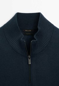 Pull tricoté marine avec col zippé, présentant une texture côtelée sur le col. Étiquette intérieure indiquant "Massimo Dutti."