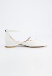 Zapatos planos de cuero blancos con punta afilada, tira en el tobillo y un pequeño tacón cuadrado; textura suave y diseño minimalista.