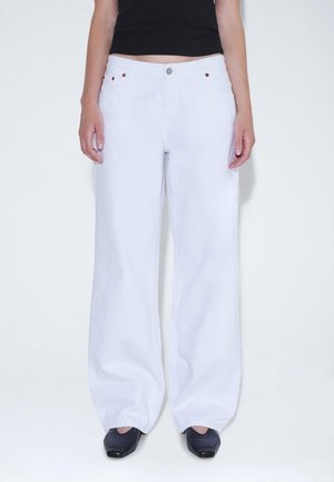 White wide-leg jeans with a high waist, made of denim. Features gold-tone hardware, a button closure, and side pockets.
