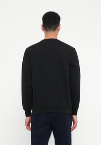 Μ�αύρη μπλούζα φούτερ από μείγμα βαμβακερού υφάσματος, με στρογγυλή λαιμόκοψη και ριμπ μανσέτες, λεία υφή και άνετη εφαρμογή.