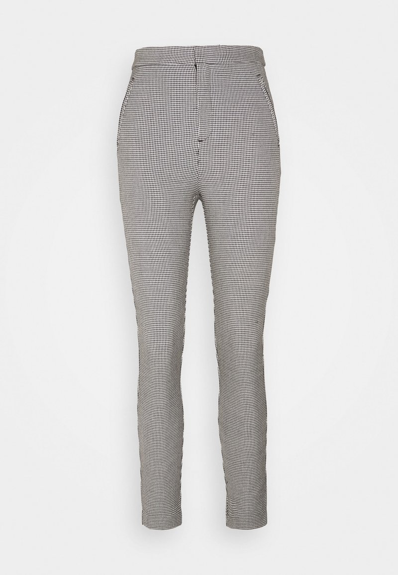 Pantalon slim taille haute avec un petit motif à carreaux noir et blanc et des poches avant sur fond blanc.