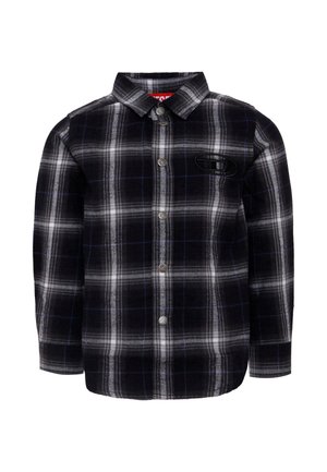 Camicia in flanella a scacchi bianca e nera con dettagli blu, maniche lunghe, chiusura con bottoni e logo a patch sul petto. Tessuto morbido e testurizzato.