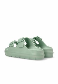Sandalias verde claro hechas de goma moldeada, con dos hebillas ajustables, tiras anchas y una suela gruesa texturizada que presenta áreas elevadas.