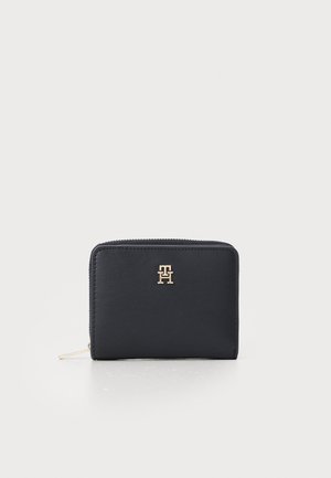 Navy leather wallet with a gold logo on the front, rectangular shape, zipper closure, smooth texture, and minimalistic design.