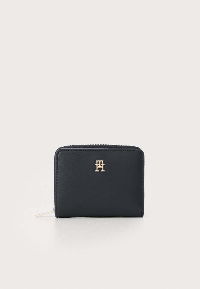 Navy leather wallet with a gold logo on the front, rectangular shape, zipper closure, smooth texture, and minimalistic design.