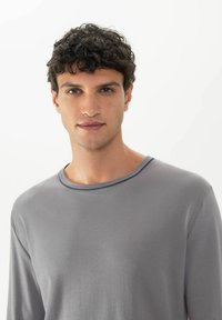 Grijze T-shirt met lange mouwen van zachte stof, met een ronde halslijn met een contrasterende bies. Soepele textuur, ontspannen pasvorm.