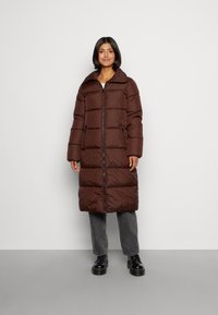Braune gepolsterte Parka mit einem Reißverschluss vorne, großem Kragen und Seitentaschen. Er hat ein langes, gerades Design und ist aus einem glatten, strapazierfähigen Stoff gefertigt.