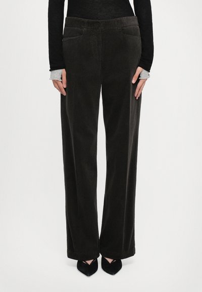 Pantalons en velours côtelé à jambe large de couleur marron foncé avec un tissu texturé, comportant des poches avant et une fermeture à bouton à la taille.
