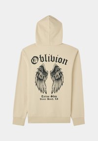 Felpa beige con un grande graffito di ali nere e testo "Oblivion" sulla schiena. Presenta un cappuccio con cordino e polsini a costine.