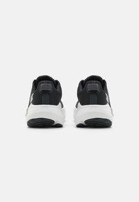 Black athletic shoes with textured fabric upper, padded collar, and white sole featuring a rubber outsole for traction.