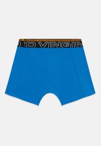Blå bomullsboxer med svart elastisk midjebånd som har gul tekst. Flate sømmer og design som når midt på låret.