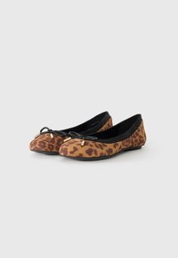 Ballerines en suède doux à imprimé léopard, avec une bordure noire et un détail en nœud avec de petites accents dorés. Semelle plate et bout rond.