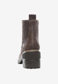 Hnědé kožené kotníkové boots s texturovaným povrchem, elastickým bočním panelem a pevnou gumovou patou s protiskluzovou funkcí pro stabilitu.