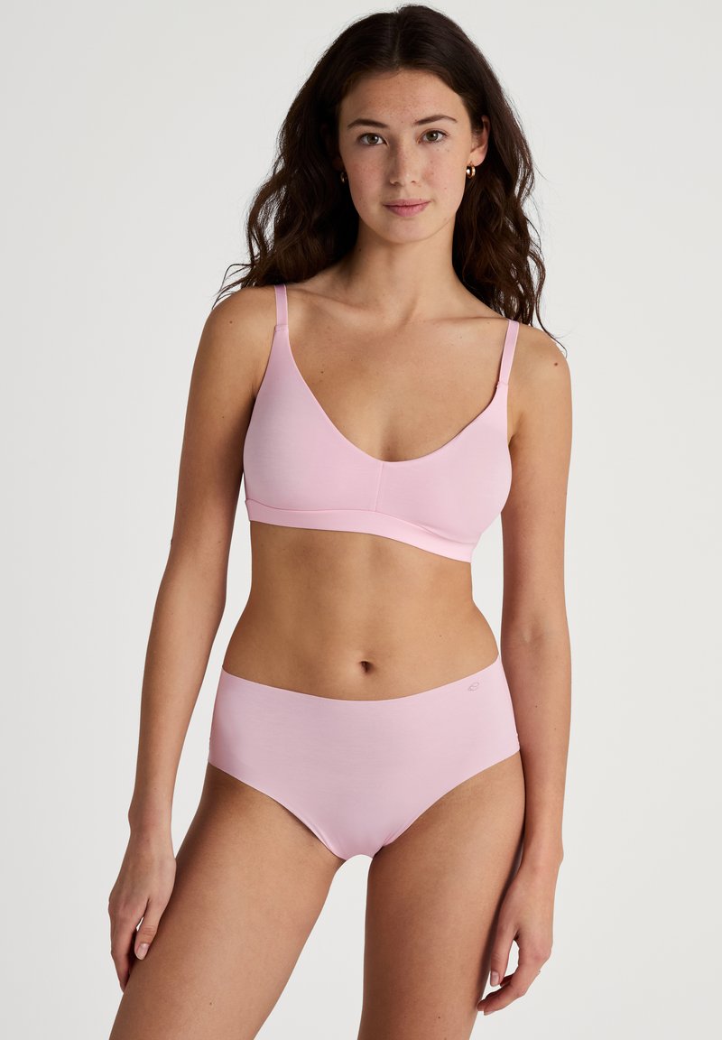 Lichtroze naadloze bh met verstelbare bandjes en een zachte, gladde textuur, gecombineerd met bijpassende hoge taille slipjes, beide bieden een comfortabele pasvorm.
