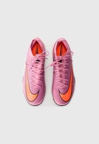 Pink and purple athletic shoes with a prominent black Nike swoosh and orange accent, featuring a textured upper and laces.