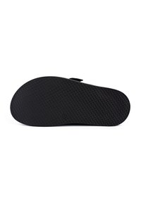 Black rubber shoe sole with a textured, patterned surface and rounded edges for grip. Features a smooth heel area and minimal design.